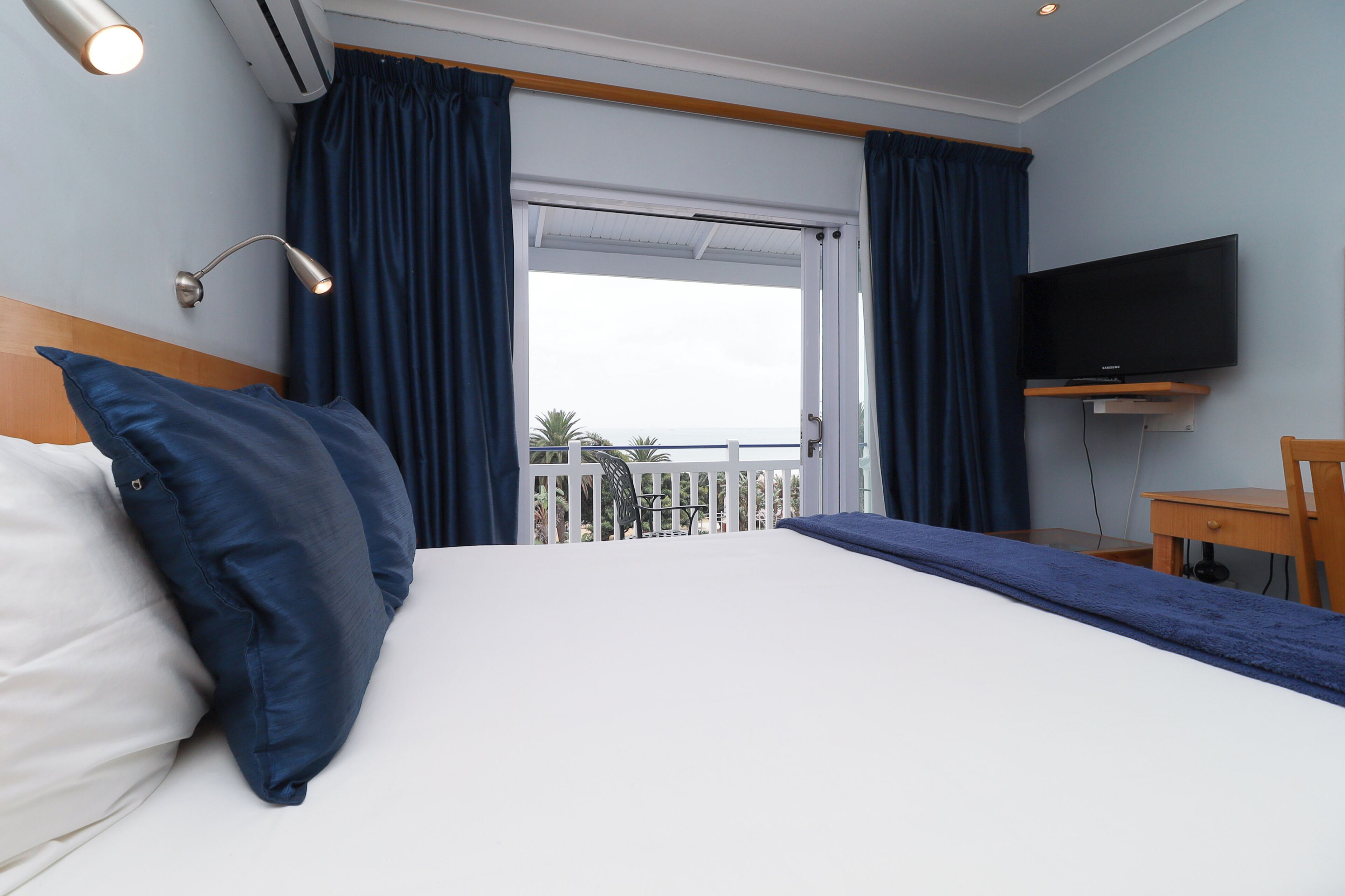Luxe kamer, uitzicht op zee | Een minibar, een kluis op de kamer, een bureau, een laptopwerkplek