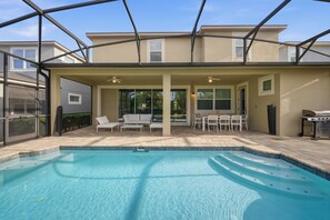 Step outside to a lovely screened patio with a sparkling pool, ideal for sunbathing or outdoor dining. The stylish furniture and inviting atmosphere create the perfect setting for relaxation and enjoyment. - 9BR house with private pool at Solara Resort (Kissimmee)