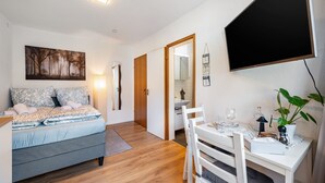 Un dormitorio con cama, mesita de noche y un cuadro en la pared.