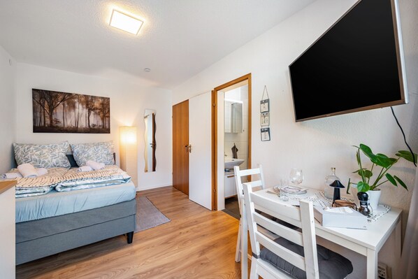 Ein Schlafzimmer mit Bett, Nachttisch und einem Bild an der Wand.
