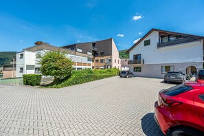 Ein Wohngebiet mit modernen Gebäuden, einem gepflasterten Auffahrtsweg und geparkten Autos.