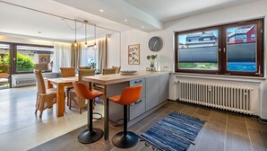 Una cocina moderna con comedor, un ventanal con vistas y un reloj integrado.