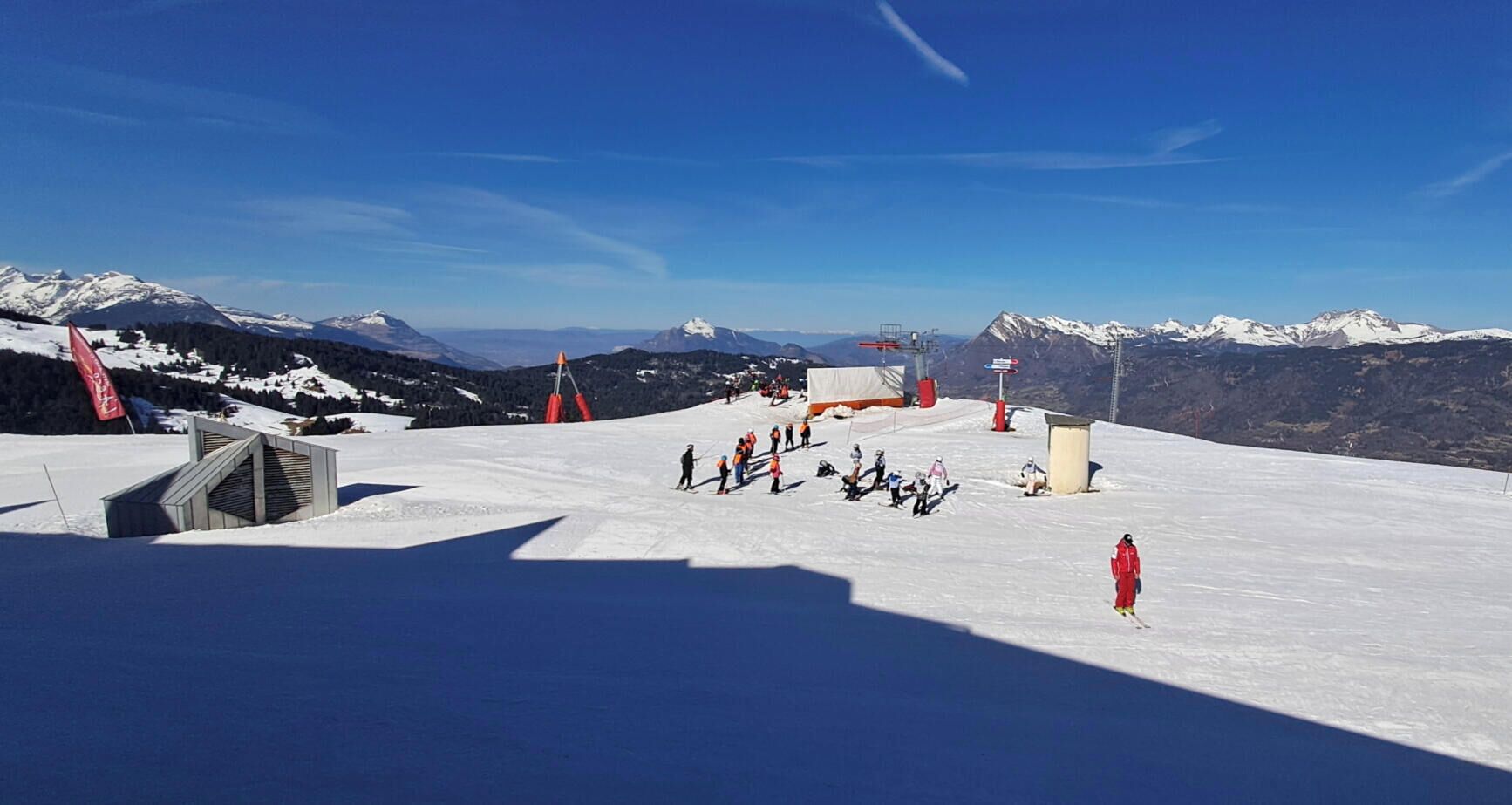 Een piste met skiërs, een skilift en een berg op de achtergrond.