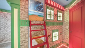 A room with a brick wall, a red door, a ladder, and a window with shutters. - 5BR house sleeps 14 near Disney area (Clermont)