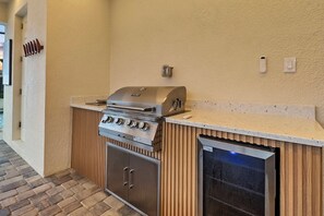 Eine kompakte Außenküche mit integriertem Grill, Backofen und Geschirrspüler.