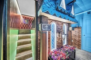 Eine Toilette im maritimen Stil, darunter ein Schiffsschwitzer, ein Bullaugenfenster und ein Blumenkasten.