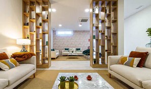 A living room with a sofa, coffee table, and a bookshelf. - Luxury Sea, Pool & Mountain View Apt near La Cala (Mijas Costa)
