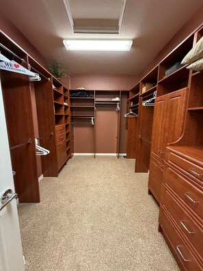 Ein begehbarer Kleiderschrank mit Holzböden, Schubladen und Platz zum Aufhängen.