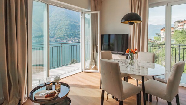 Une chambre moderne avec un balcon, une table à manger et un téléviseur.