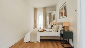 Une chambre à coucher avec un lit, une table de chevet, une lampe et un tableau encadré au mur.