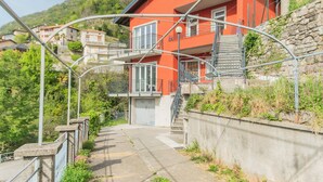 Un edificio rosso con un balcone, una scala e vista su una collina.