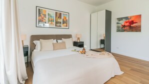Una camera da letto con un letto, comodini, uno specchio e opere d'arte alle pareti.