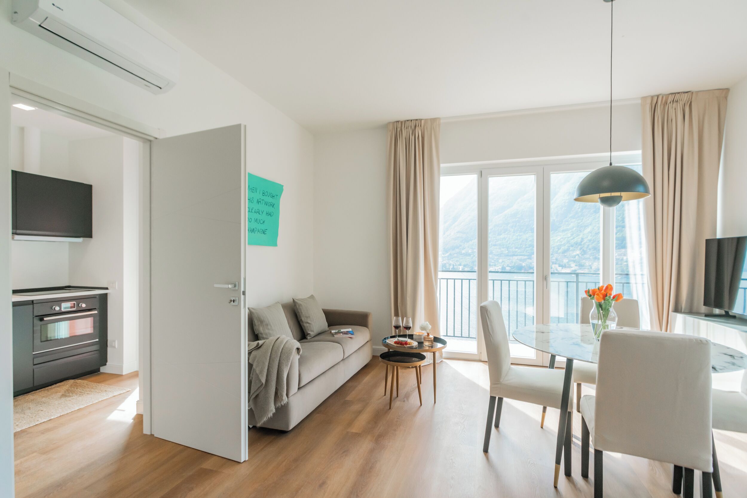 Un salon moderne comprenant un canapé, une table à manger, des chaises, un téléviseur et un balcon avec vue.