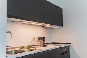 Une cuisine moderne équipée d’un four encastré, d’un évier et d’un plan de travail avec un porte-verres.