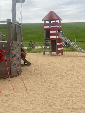 Ein Spielplatz mit einer Kletterkonstruktion und einer Rutsche.