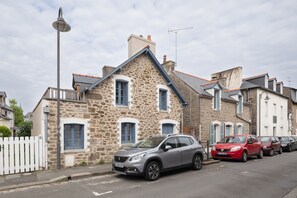 A stone building with a grey car parked in front. - La Petite Maison Bleue - À 400 m de la plage (Dinard)