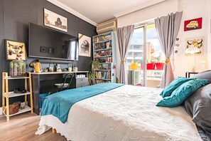 A bedroom with a bed, a desk, a bookshelf, and a TV. - Le Lyautey - Charmant appt avec terrasse (Ajaccio)
