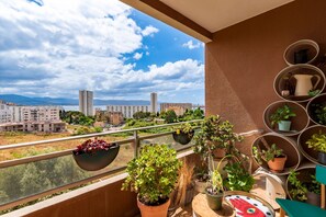A balcony with potted plants, a view of a cityscape, and a clear sky. - Le Lyautey - Charmant appt avec terrasse (Ajaccio)