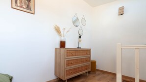 A room with a wooden dresser, a mirror, and a vase with dried plants. - Le Nid Phocéen - À 700 m du Vieux-Port (Marseille)
