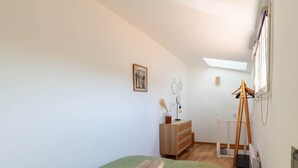A room with a bed, a dresser, a radiator, and a skylight. - Le Nid Phocéen - À 700 m du Vieux-Port (Marseille)