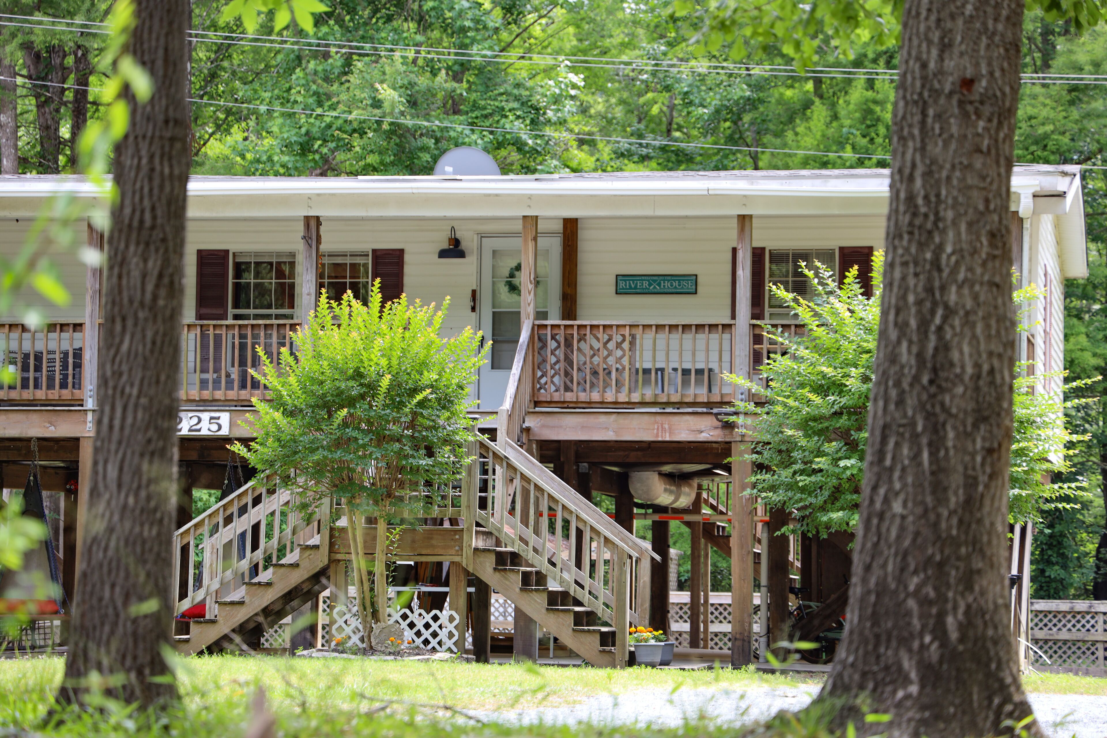 A two-story building with a porch, a staircase, and a sign that reads 'River House.'