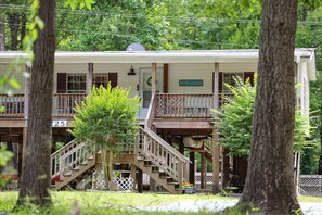 A two-story building with a porch, a staircase, and a sign that reads 'River House.'