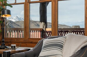 Ein gemütliches Zimmer mit Bergblick, einer Lampe, einer Kerze und einem Streifenmuster-Kissen.