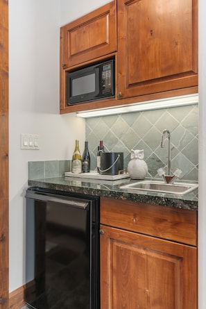 A kitchen with wooden cabinets, a microwave, a dishwasher, a sink, and a tiled backsplash. - Outpost: Grand View 363S - Air Conditioning! (Jackson)