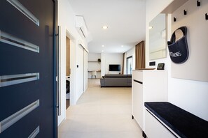 Ein modernes Interieur mit einer Couch, einem Fernseher und einer an der Wand befestigten Tasche.