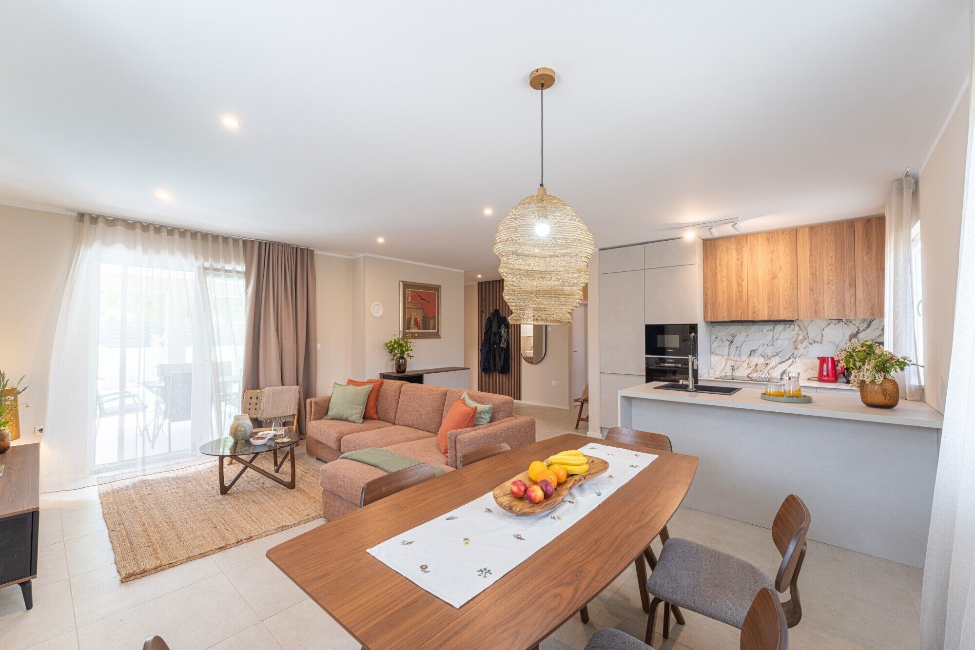 Ein modernes Apartment mit Essbereich, Küche und Wohnzimmer.
