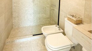 Kylpyhuone, jossa on suihku, kaksi wc:tä ja pesuallas.
