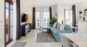A modern living room with a sofa, TV, and two small tables. - Apartment PA11 - Callysta (Kouklia)