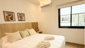 A hotel room with a large bed, a window, and a ceiling light. - Dpto. a media cuadra de la plaza principal 2 (Salta)
