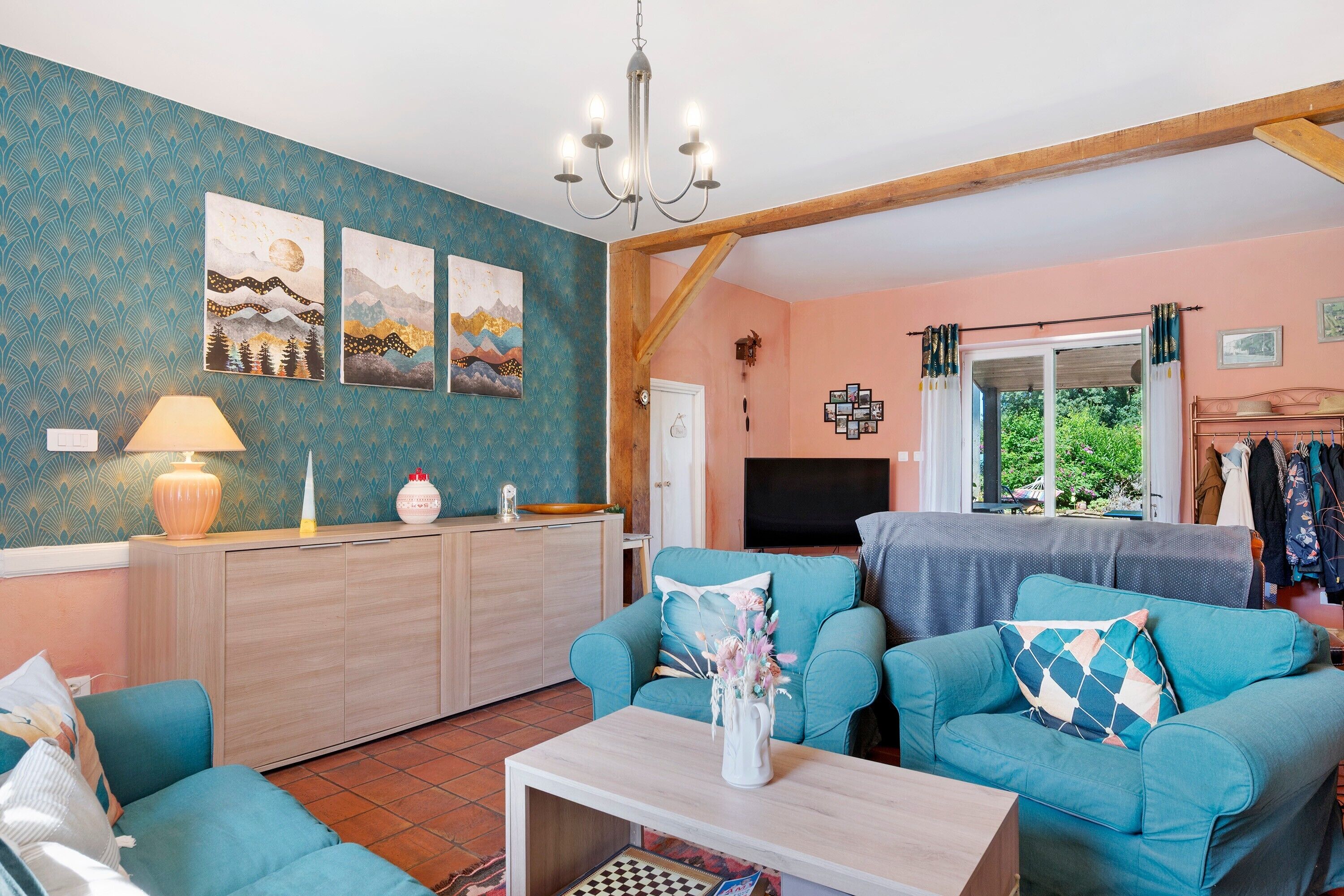 A living room with two sofas, a coffee table, a TV, and artwork on the wall.
