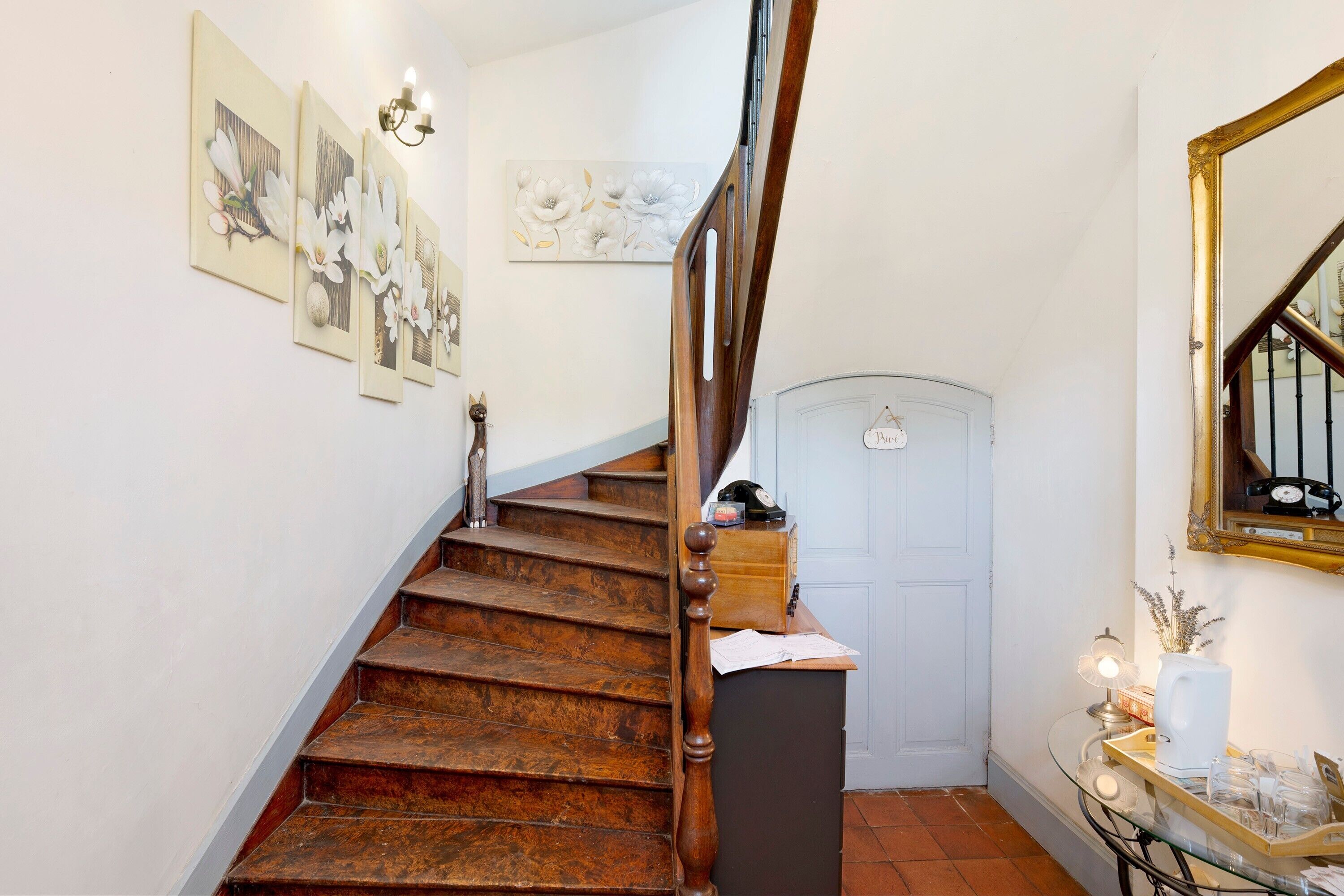 Una scala in legno con un tavolo di vetro e una porta in cima.