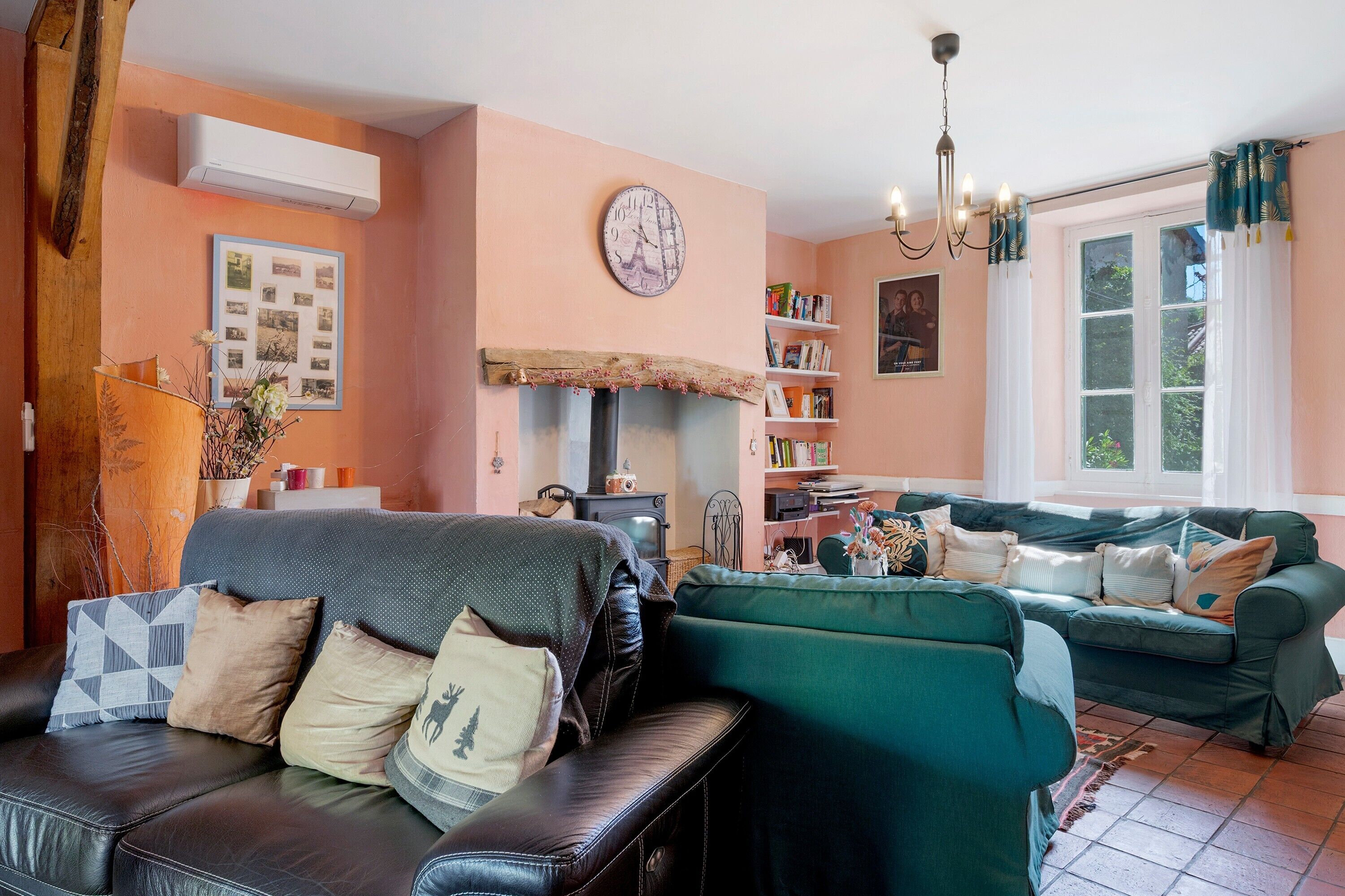 Una sala de estar acogedora con chimenea, un reloj y una estantería.