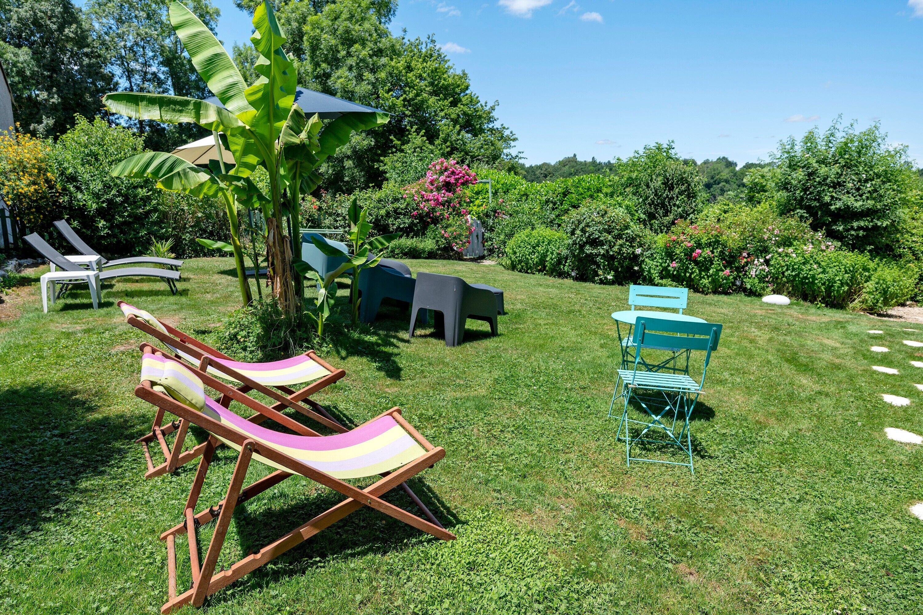 Un giardino con prato, un albero e un set tavolo e sedie.