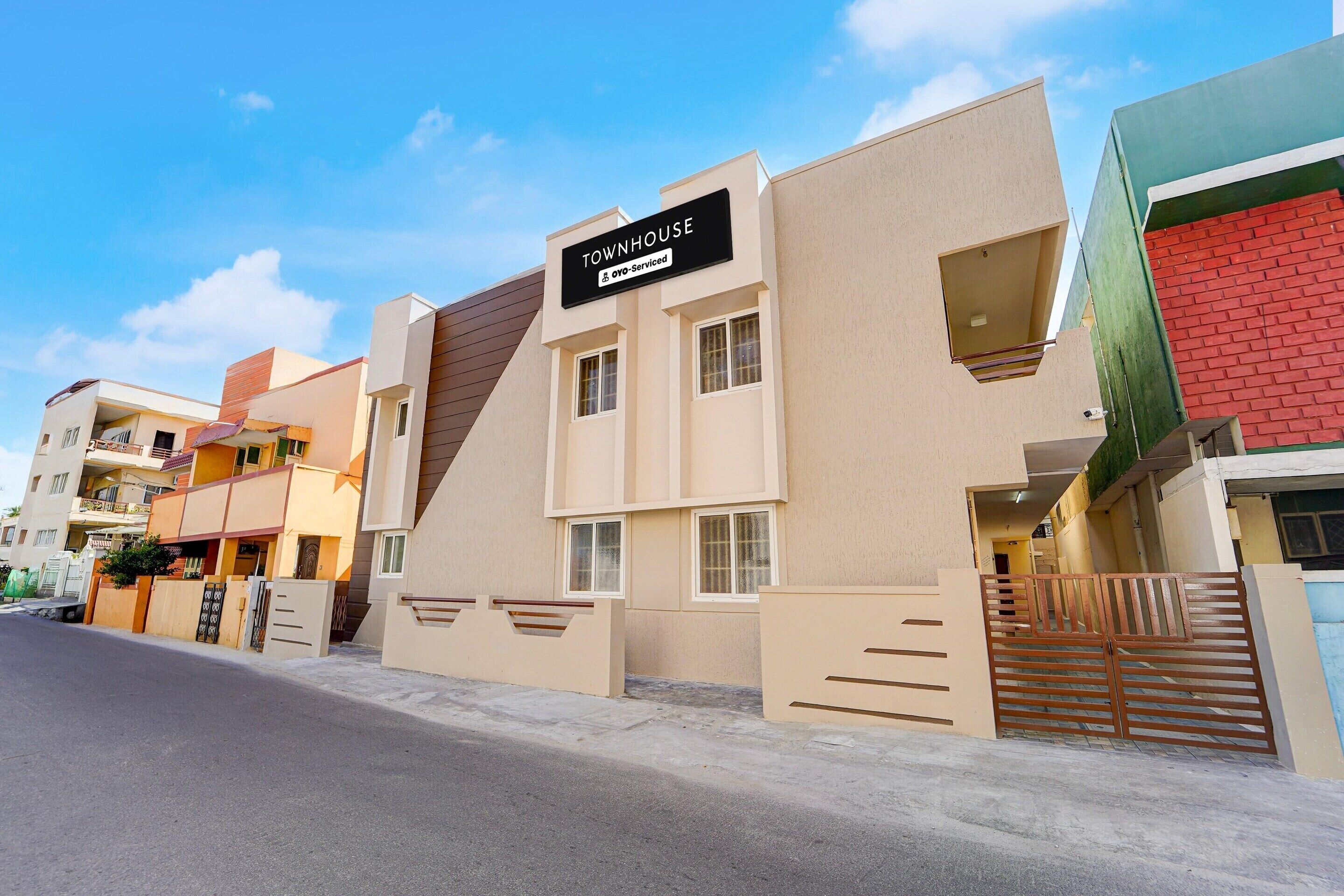 A modern townhouse with a sign indicating it is serviced by a nearby hotel.