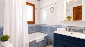 A bathroom with a bathtub, a toilet, a sink, and a mirror. - Private Pool Villa La Siesta (Torrevieja)