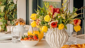 A breakfast table with a vase of flowers, a bowl of fruit, a teapot, and croissants. - Modern Luxury Villa with Panoramic  View (Marbella)