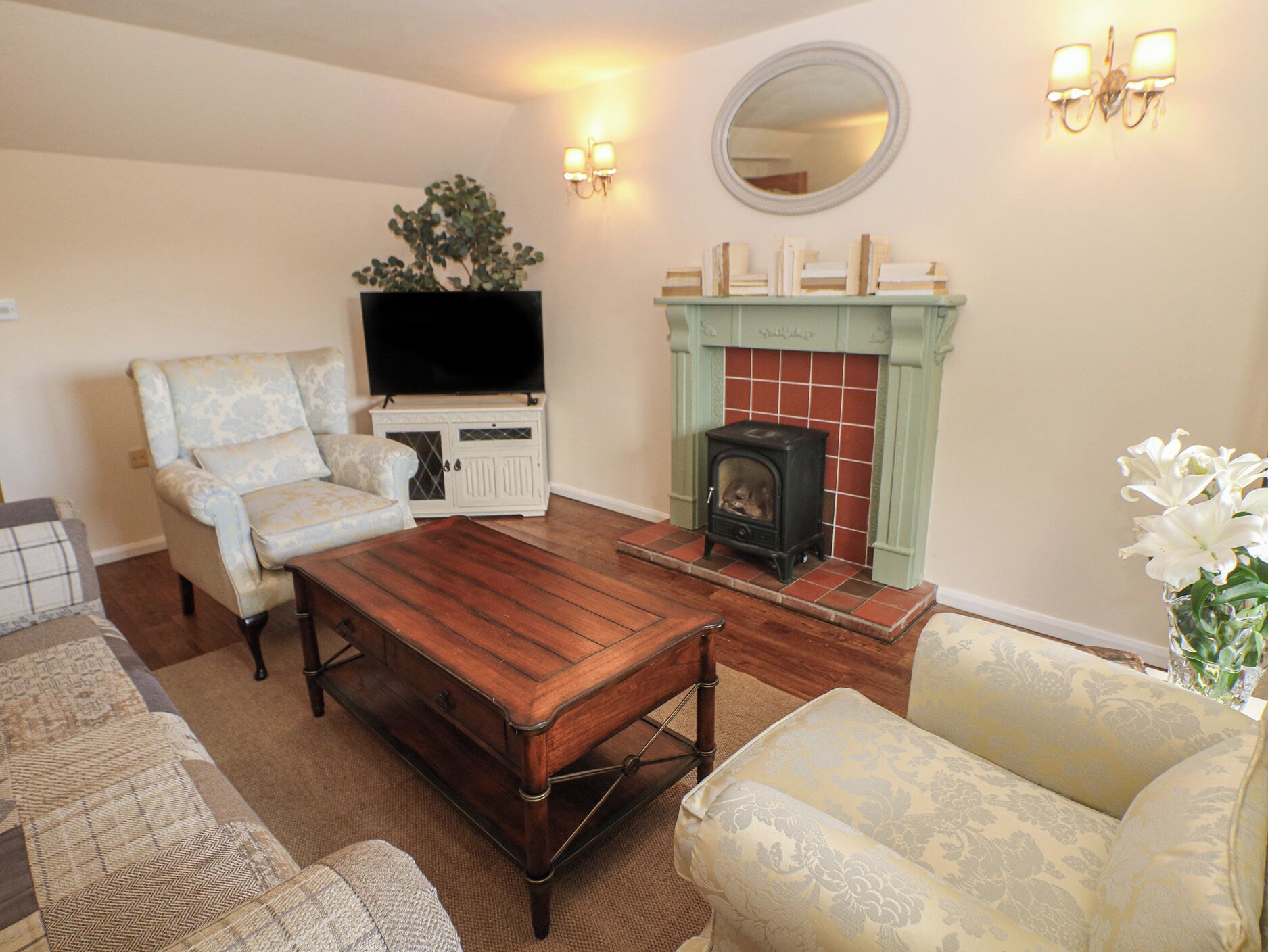 A living room with a fireplace, a television, and a sofa.