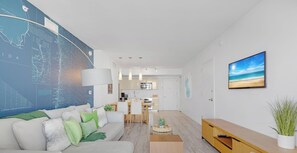 A modern living room with a large map on the wall, a dining area, and a kitchen in the background. - High-Floor Intracoastal View Apt - Beach Access (Hallandale Beach)