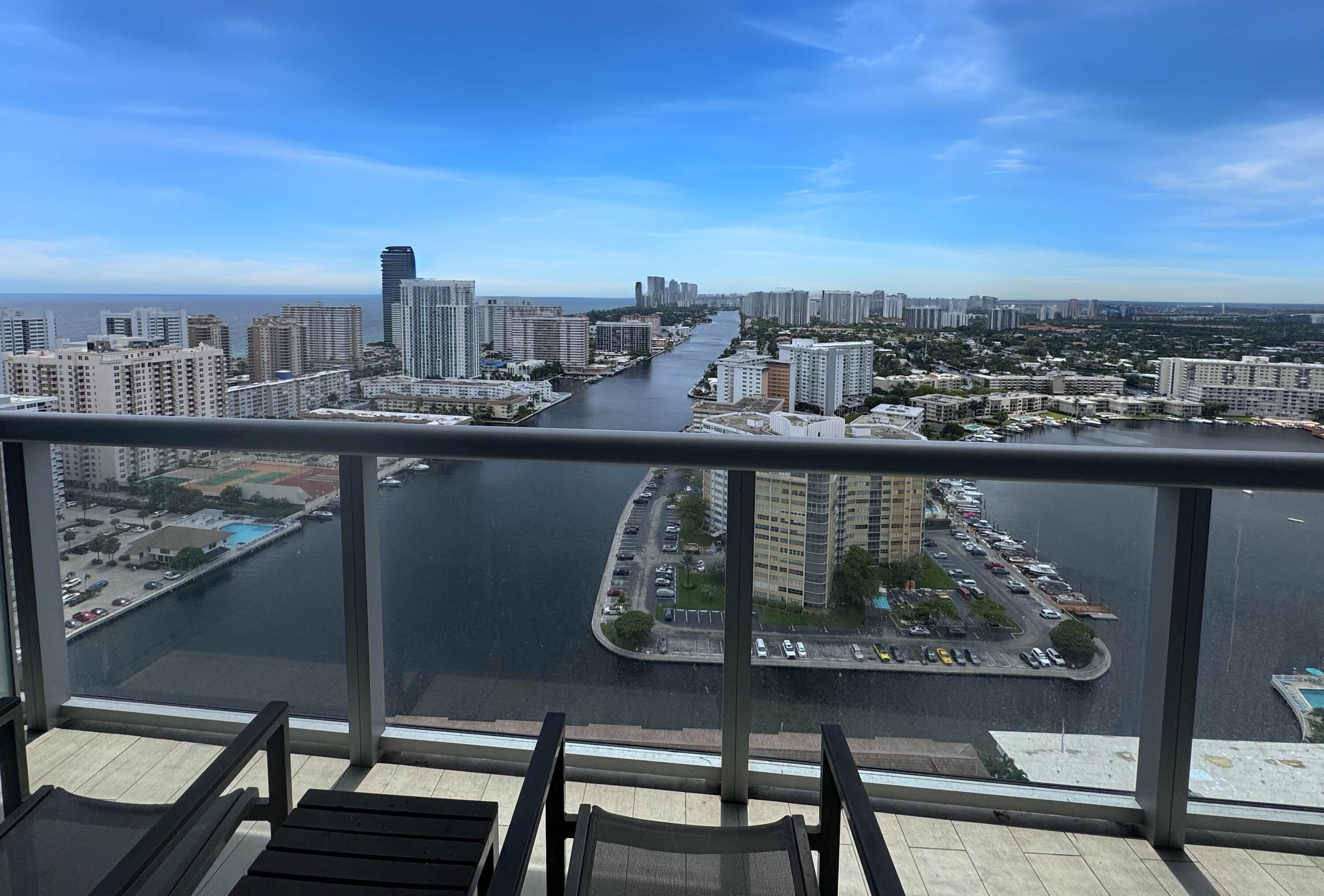 A high-rise building with a view of a river and surrounding cityscape.