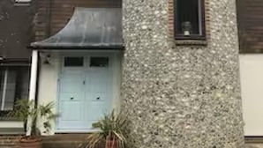 A house with a stone tower, a blue door, and a small window. - House Sleeps 9 With Indoor Pool (Chichester)