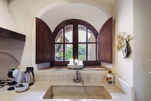 A kitchen with a large window, a sink, and a stove. - Apartment 'Podere Del Botruccio - Girasole' with Shared Pool, Garden & Wi-Fi (Pomarance)