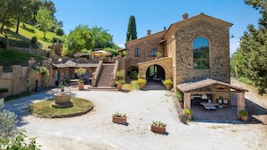 Un edificio in pietra con un cortile, posti a sedere all'aperto e una fontana.