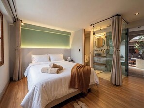 Une chambre à coucher moderne avec un grand lit, une douche en verre et une vue sur l’extérieur.
