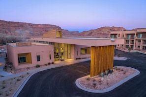 A modern hotel with a prominent wooden structure, a covered entrance, and a view of the surrounding desert landscape. - EBAC Moab (Moab)