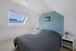 A bedroom with a skylight, a bed, a nightstand, and a wall-mounted lamp. - Holiday Home 'Gîte Aber 3km Plages' with Private Terrace, Garden & Wi-Fi (Telgruc-sur-Mer)