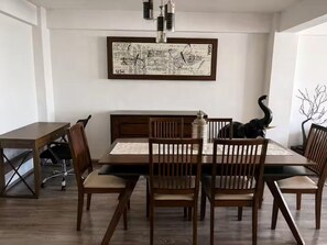 A dining area with a wooden table and chairs, a framed abstract artwork on the wall, and a decorative vase on the table. - Spacious and centrally located apartment 6 stations from downtown Mexico City and 8 from Banorte stadium. (Cdmx)
